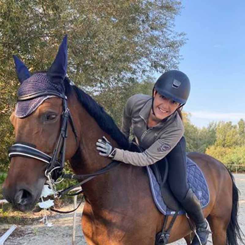 Dresseuse soigneuse qui monte son cheval
